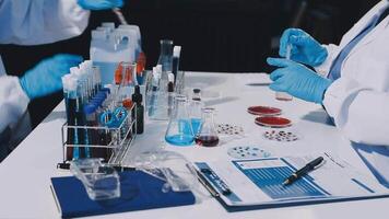 Two people in lab coats are working on a table video