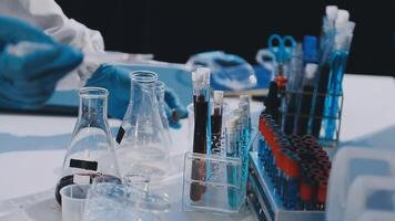 A person in a lab coat is working on a test tube video