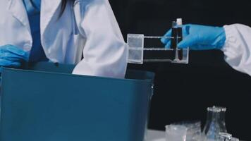 Two people in lab coats holding up a container video