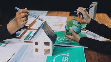 Business people working on a project with a house and a globe video