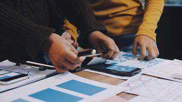 Two people working on a project together with papers and pens video