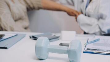 A doctor is holding a dumbbell in front of a desk video