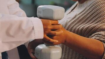A woman is holding a dumbbell while a man is holding it video