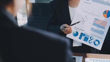 A businesswoman is holding a piece of paper with graphs on it video