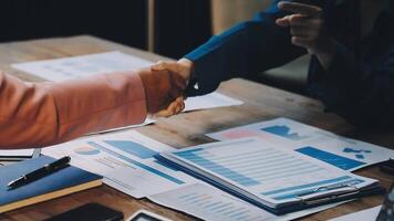 Two people shaking hands over papers on a table video
