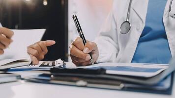Two doctors are working on paperwork at a desk video
