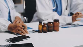 Two doctors sitting at a table with bottles and pills video