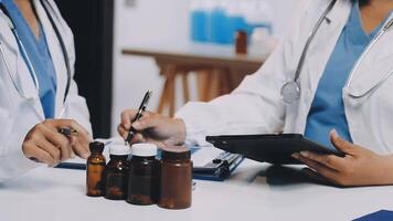 Two doctors are working on a tablet with bottles video