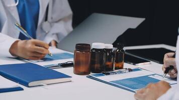 Two doctors are working on a laptop and a tablet video