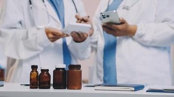 Two doctors are looking at a tablet and bottles video