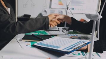 Two business people shaking hands at a desk video