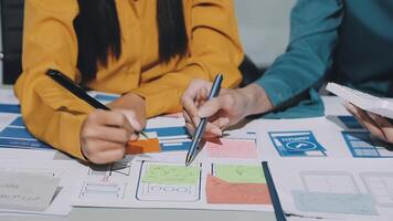 Two people working on a project with paper and pens video