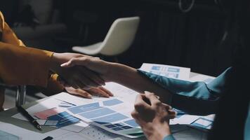 Two people shaking hands over a table with papers video