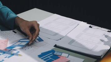 A person is working on a project with a laptop and papers video