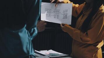 Two people are looking at a paper with a diagram on it video