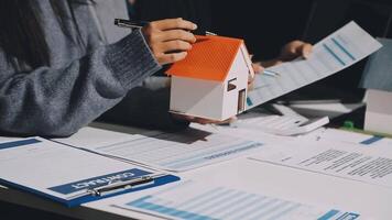 A woman is holding a house model on a desk video