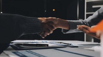 Two people shaking hands over a desk video
