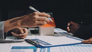 Two people sitting at a table with papers and pens video