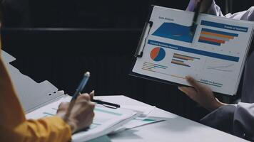 Two people are looking at a chart on a clipboard video