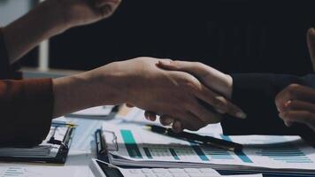 Two business people shaking hands over a desk video