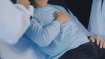 A man is sitting in a hospital bed with his chest on the table video