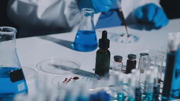 A person in a lab coat is working on a test tube video