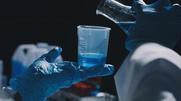 A person in a lab coat holding a beaker video