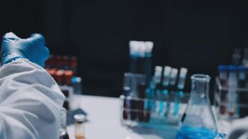 A person in a lab coat is holding a test tube video