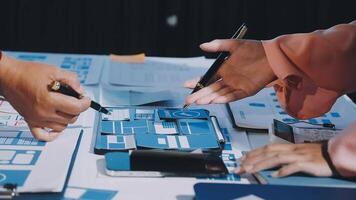 Two people working on a table with blue and white papers video