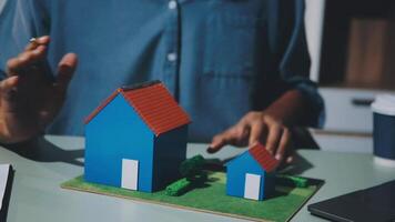 A person is holding a model of a house on a table video