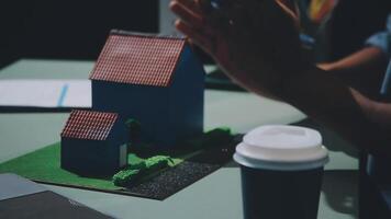 A person clapping at a model of a house video
