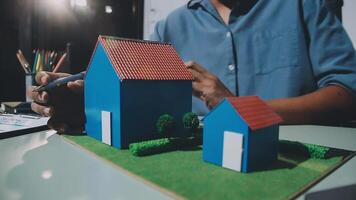 A man is working on a model of a house video