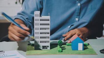 A man is working on a model of a house and a building video