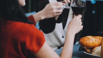Two people toasting with wine glasses at a table video