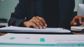 A person is working on paperwork at a desk video