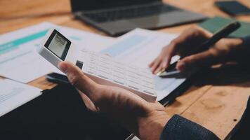 Businessman using calculator to calculate the cost of a project video