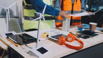 Two men working on a table with wind turbines video
