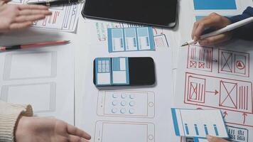 A group of people working on a project with paper and pens video