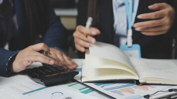 Business people working on a calculator and notebook video