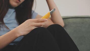 A woman sitting on a couch holding a yellow toothbrush video