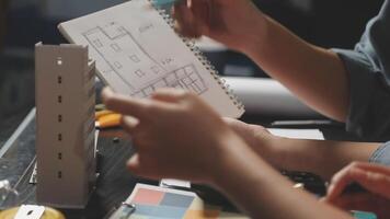 A person is working on a project with a blue notebook video