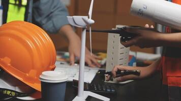 A person working on a project with a hard hat and a wind turbine video