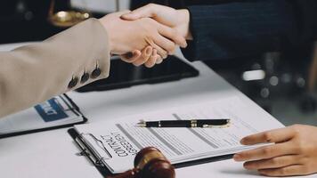 Two people shaking hands over a desk with a pen and paper video