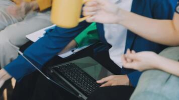 A group of people sitting on a couch with laptops video