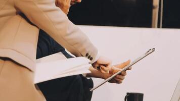 Two people are holding a tablet computer and one is looking at it video