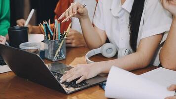 A group of people sitting at a table with laptops video