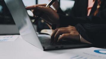 A person using a laptop computer with a pen and paper video