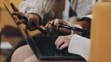 A person using a laptop with a pen and paper video