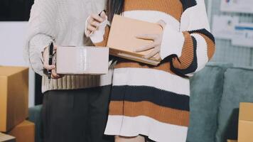 Two people holding boxes in front of a couch video
