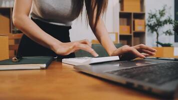 A woman using a calculator on a laptop video